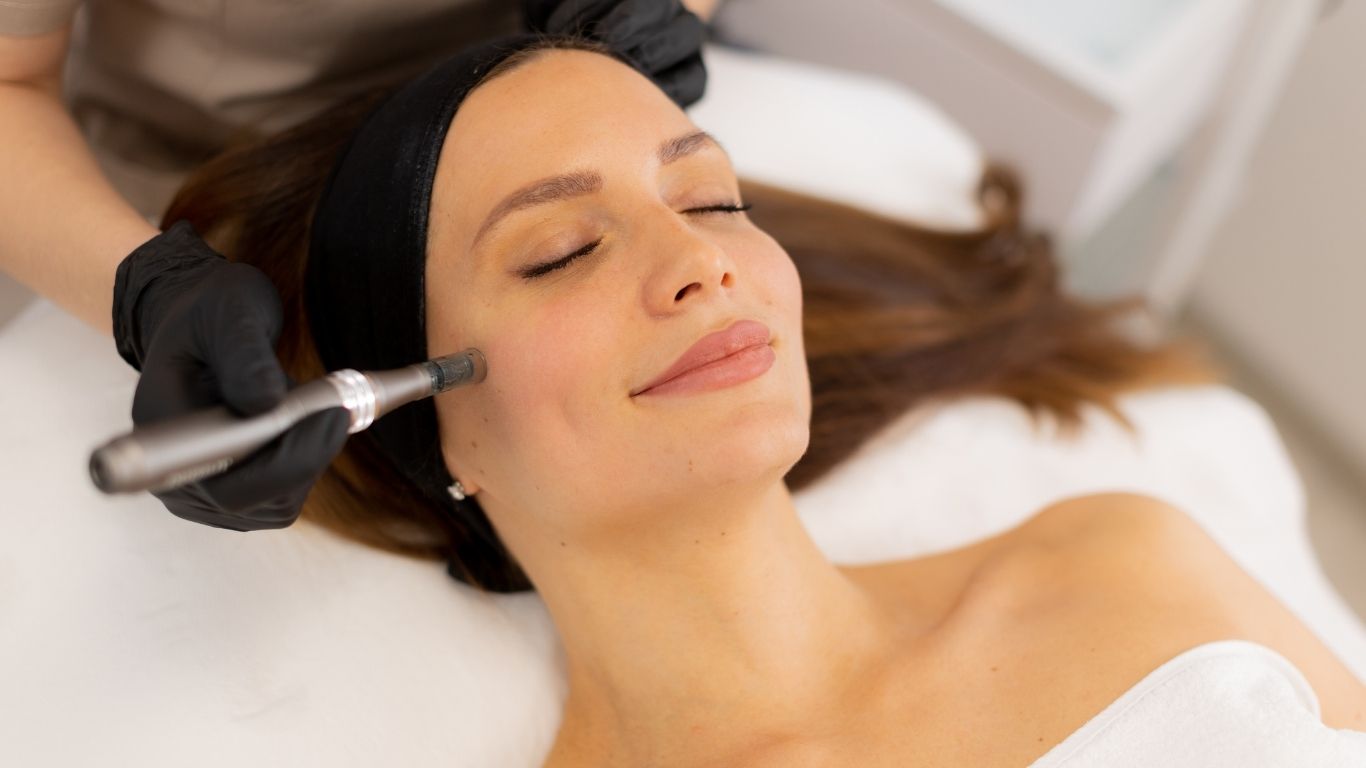 Aesthetic provider performing a microneedling skin treatment on a relaxed client in a bright treatment room at Tula Tu Aesthetics in The Woodlands, TX